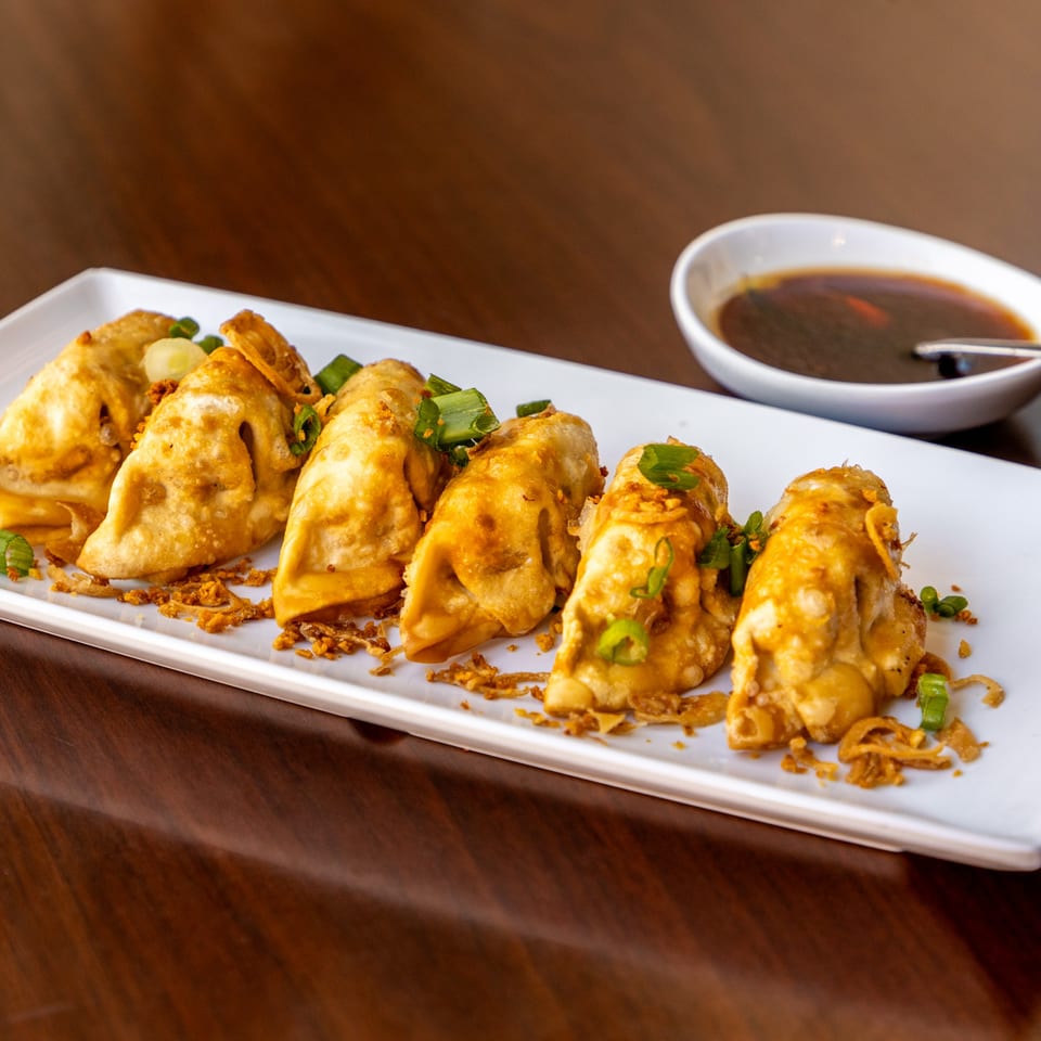 Six crispy fried Vietnamese dumplings with green onions and fried garlic, served with dipping sauce.